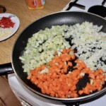na patelni smażą się drobno siekane warzywa