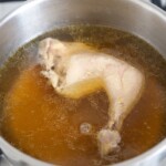 ugotowana noga z kurczaka w rosole w garnku
