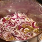 w garnku smaży się siekana czerwona cebula