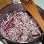 w garnku smaży się posiekana w pióro czerwona cebula