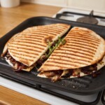 quesadilla z pieczarkami grzeje się na patelni grillowej