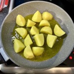 na patelni smażą się na oliwie kawałki ziemniaków