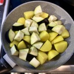 na patelni smażą się na oliwie kawałki ziemniaków i bakłażana