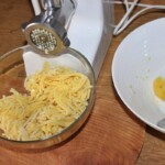 ugotowane ziemniaki przepuszczane są przez maszynkę