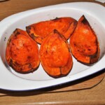 upieczone cztery kawałki dyni znajdują się w naczyniu żaroodpornym