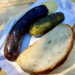 Krupniok z grilla na tacce z ogórkiem kiszonym i kromką chleba