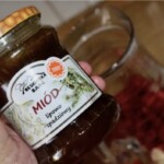 słoik miodu w dłoni