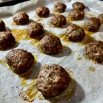 klopsiki wieprzowe upieczone leżą na blasze z piekarnika