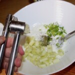 w misce znajdują się pokrojone ogórki i dymka oraz czosnek