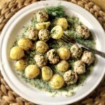 klopsiki mięsne ziemniakami na talerzu polane sosem koperkowym