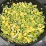 na patelni smażą się kawałki selera naciowego razem z ziemniakami krojonymi w kostkę oraz drobno siekaną cebulą