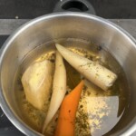 w garnku ugotowany jest bulion warzywny jarzynowy razem z warzywami korzeniowymi