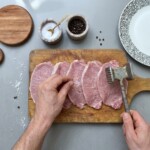 rozbite kotlety schabowe leżą na desce kuchennej