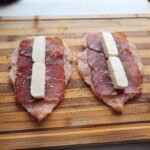 na rozbite piersi z kurczaka nakładana jest szynka dojrzewająca i kawałek mozzarelli